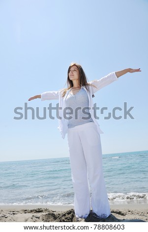 happy young woman relax on beautiful  beach at fresh summer morning and enjoy first ray of sun