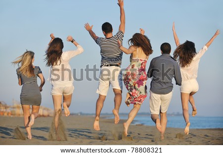 happy young people group have fun  run and jump  on beach beautiful sand  beach