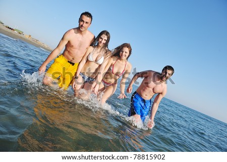 happy young people group have fun  run and jump  on beach beautiful sand  beach