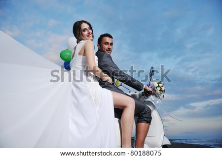 wedding scene of bride and groom just married couple on the beach ride white scooter and have fun