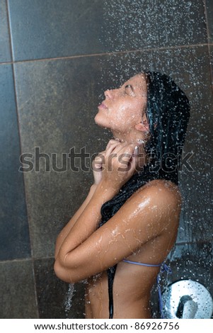 Portrait of a sexy young woman enjoing bath under water shower