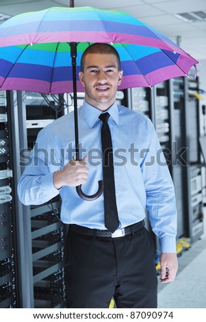 young handsome business man  engineer in  businessman hold  rainbow colored umbrella in server datacenter room  and representing security and antivirus sofware protection concept