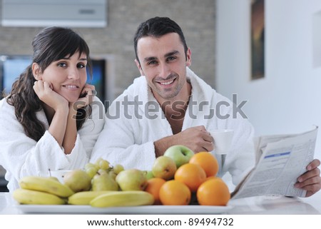 young family couple read newspaper at kitchen in morning with  fresh breakfast  fruits food and coffee drink on table