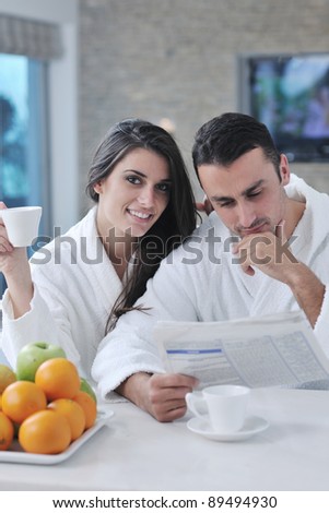 young family couple read newspaper at kitchen in morning with  fresh breakfast  fruits food and coffee drink on table
