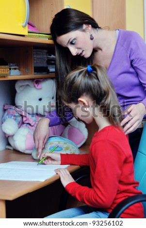 happy family woman and girl working on homework at home while mom showing globe and giving help
