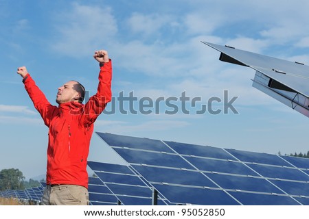 Male engineer at work place, solar panels plant industry in background