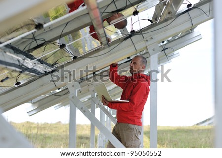 business man  engineer using laptop at solar panels plant eco energy field  in background