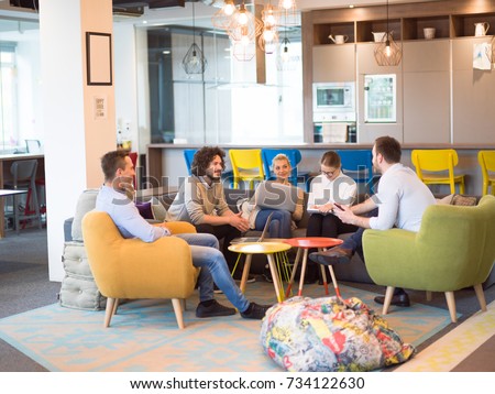 Group of a young business people discussing business plan at modern startup office building
