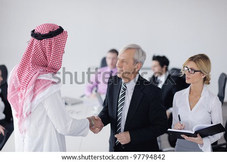 Business meeting - Handsome young Arabic  man presenting his ideas to colleagues and listening for ideas for success investments at bright modern office room