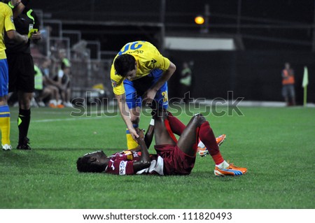 CLUJ-NAPOCA, ROMANIA - SEPTEMBER 2: Fair play of M. Laurentiu (yellow) after a  fault against M. Sougou (red) during a match between CFR Cluj - P. Ploiesti, final score 2-2, Sept 2, 2012 in Cluj, RO