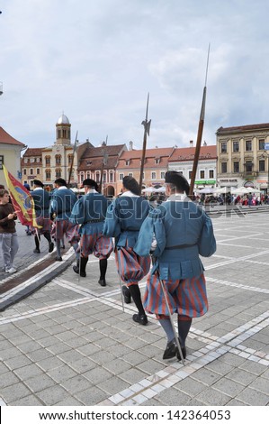 BRASOV, ROMANIA - JUNE 7: Medieval royal guards marching through the Council Square. Brasov is one of the most popular saxon medieval city of Romania. In Brasov, Romania, on June 7, 2013.