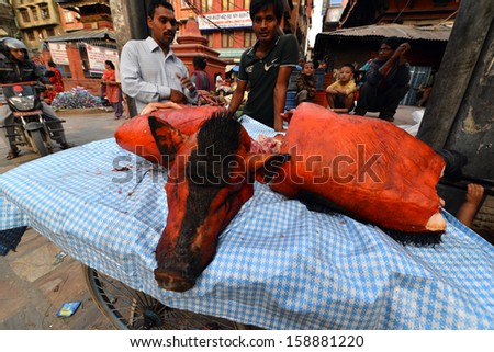 KATHMANDU - SEPT 28: Street food seller selling a pig on Sept 28, 2013 in Kathmandu, Nepal. Hygienic condition of the food in the Nepalese rural markets are often suspicious