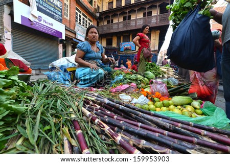 KATHMANDU, NEPAL - SEPT 28: An unidentified local merchant woman selling vegetables in the street during the Dashain festival, on September 28, 2013 in Kathmandu, Nepal