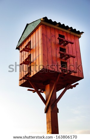 Wooden birdhouse on a wooden post in the outdoors
