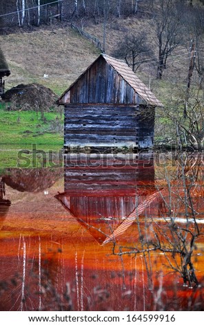 An abandoned house flooded by polluted water from a copper open cast mine