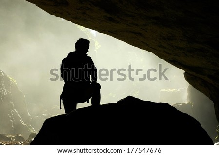 Silhouette Of A Man Standing In Front Of A Cave Entrance