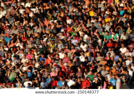Blurred crowd of people at a football match in a stadium