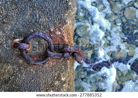Rusty boat chain anchor on the coast