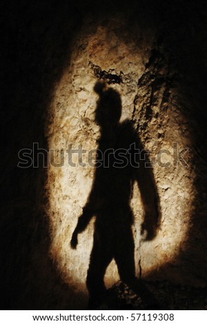 Caver shadow on a cave hall's wall