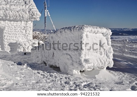 Snow covered, frozen car at winter near a meteorological station