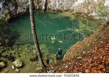 A cave diver emerges from a spring