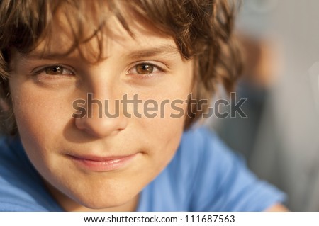 European school-age boy with brown eyes looking directly at the camera, close-up