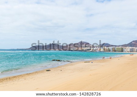 sandy beach, blue ocean, the sky in the clouds and cape, stretching into the ocean