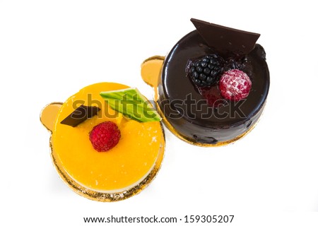 fruit and chocolate cake decorated with fruit on a white background, shot from above
