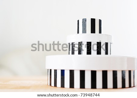 Tower of round boxes in black and white stripes