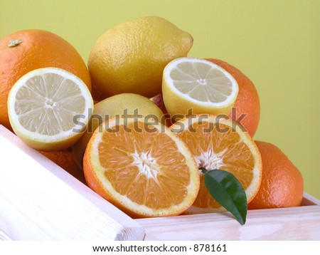 box of sweet oranges and fresh lemons on blue background