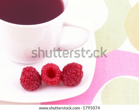 cup of tea with raspberry syrup and some fresh raspberries