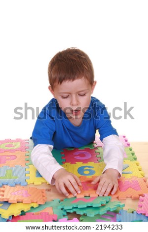five years old boy playing with colorful letters isolated on white