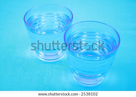 two glasses of pure water on blue background