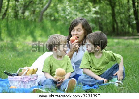 mother and sons relaxing - family picnic in the forest
