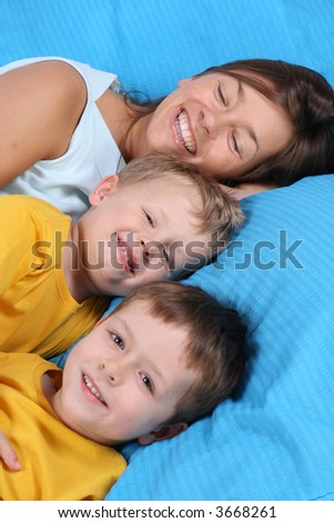mother and two sons in bed - smiling faces