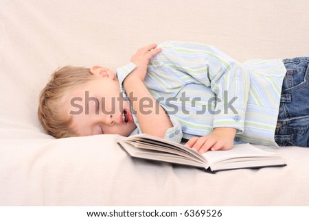 3-4 years old boy with book on the sofa