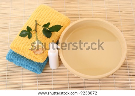 bowl of pure water fresh rose and towels