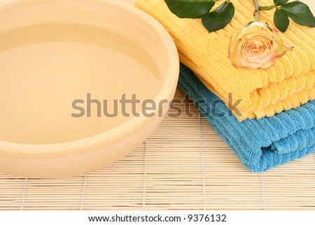 bowl of pure water fresh rose and towels