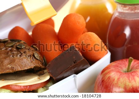 box with sandwich fruits and chocolate and bottle of juice