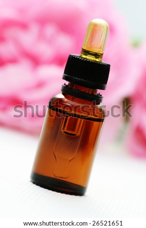 bottle of essence oil with pink flowers - beauty treatment
