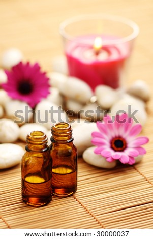 bottles of essence oil with pink flowers - beauty treatment