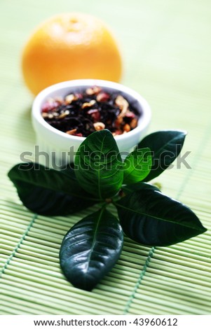Bowl of tangerine tea with fresh fruit - tea time /focus on leaves/