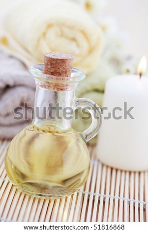 bottle of massage oil with towels and flower - beauty treatment