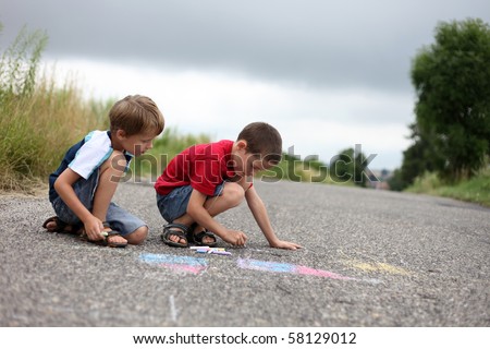 two young boys drawing with sidewalk chalk - family and kids
