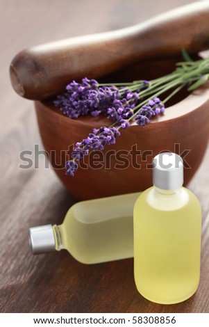 bottle of lavender massage oil with mortar and pestle - beauty treatment