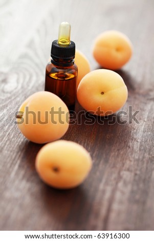 bottle of essential oil with fresh apricots - beauty treatment