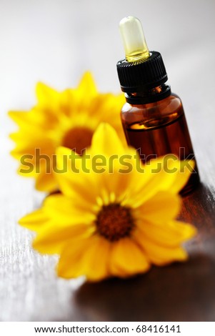 bottle of flower essential oil with yellow flowers - beauty treatment