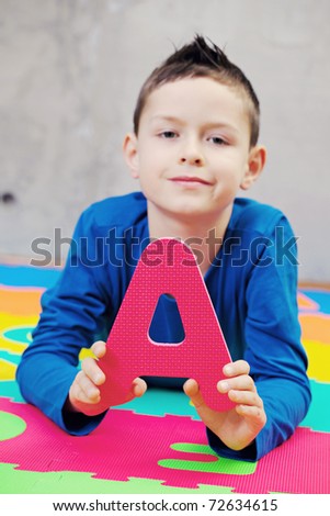 9 years old boy with alphabet letters - kids and family /focus on letters/