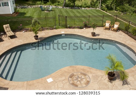 Luxury salt water pool and patio in a residential backyard.