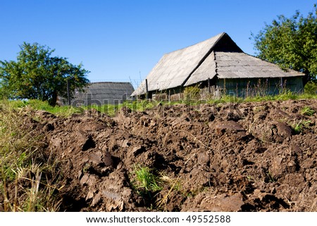 arable land on village barn and sky background